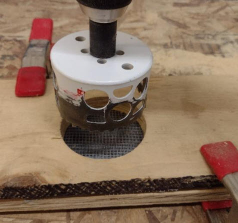 Hole saw lining up to cut the hardware cloth.